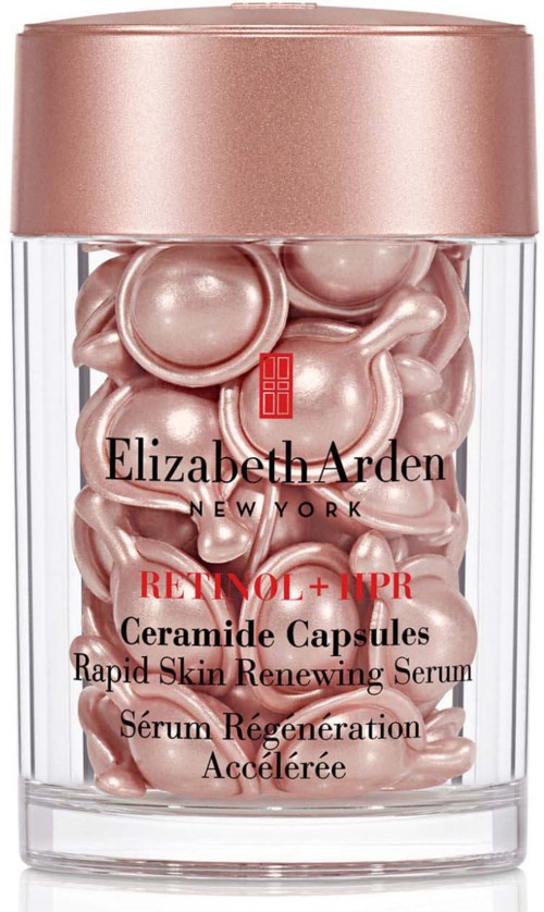 Ruusukultainen kapselit kirkkaassa astiassa vaaleanpunaisella kannella, Elizabeth Arden, ihon uudistustuotteet.