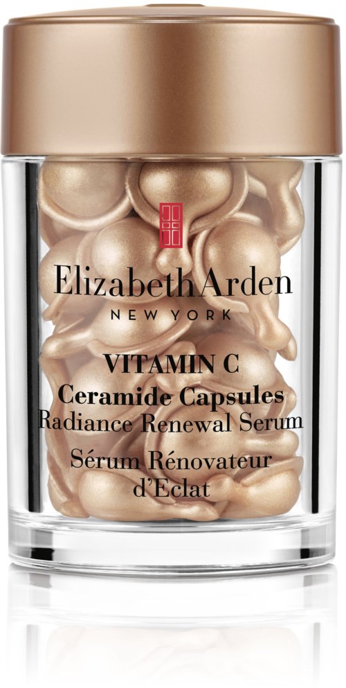 A clear container holds cream-colored capsules labeled as Elizabeth Arden Vitamin C Ceramide Capsules for skincare.
