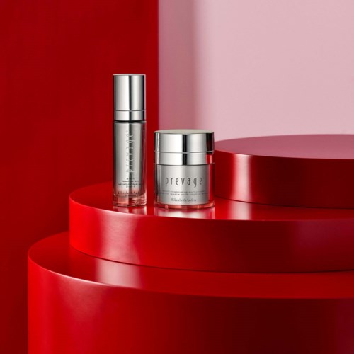 Two skincare products are displayed on a red round platform, with a red and pink background.