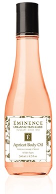 Vaaleanpunainen lotionpullo, jossa lukee Éminence Apricot Body Oil, musta korkki ja valkoinen etiketti.
