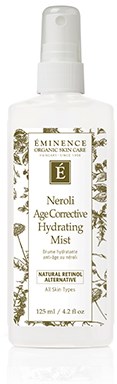 A white spray bottle with gold and black label, called Éminence Neroli Age-Defiant Hydrating Mist.