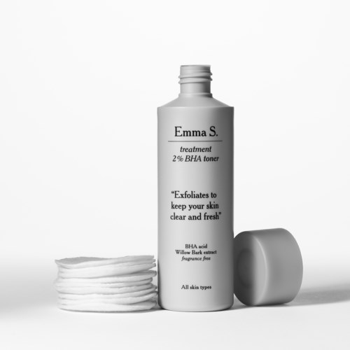 A skincare bottle labeled Emma S, with cotton pads and a cap, on a clean background.