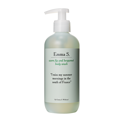 A white bottle with a pump, labeled Emma S. warm fig and bergamot body wash, featuring a quote about summer mornings.