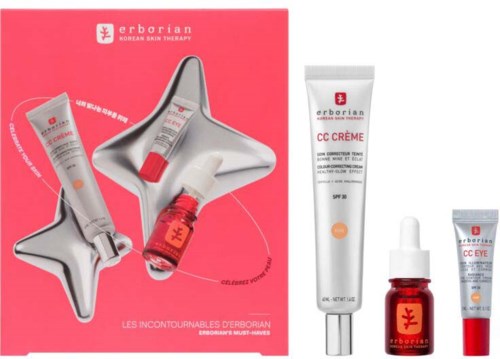 A skincare set with tubes, a bottle with a dropper, and star-shaped containers in a pink box.