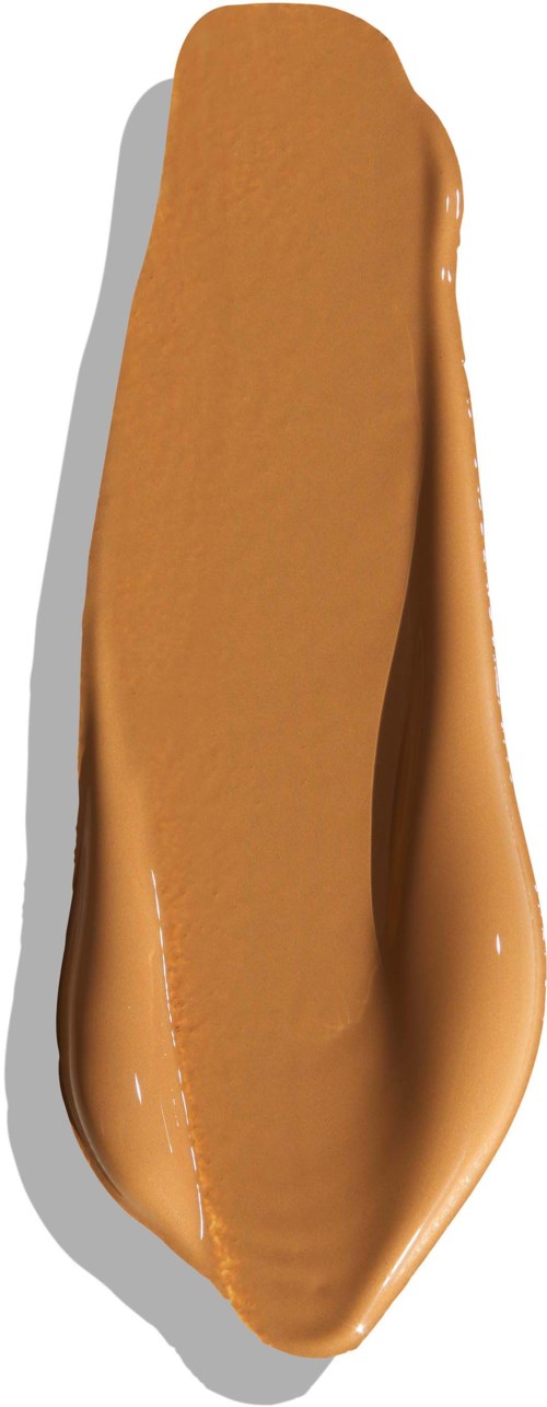 A spoon with caramel or brown sauce on it, shaped like a leaf or elongated teardrop.