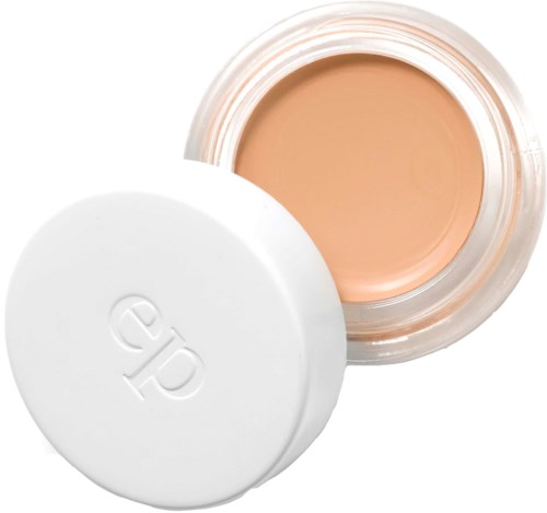 Een container met een witte deksel, gevuld met beige crème, waarschijnlijk make-up of huidverzorgingsproduct.