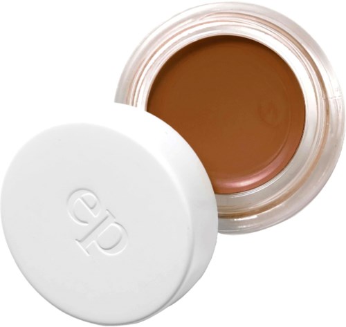 En liten burk med beige kräm inuti och ett vitt lock. Lockets har en logga på.