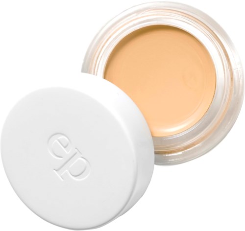 A small jar with light beige foundation, lid is off, showing the product inside.