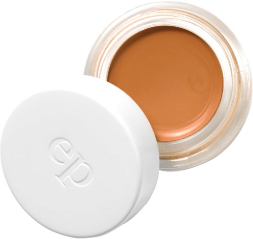 En burk med foundation smink medvit lock, visar beige färg inuti.