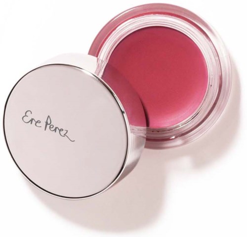 Een roze blush of make-upproduct in een doorzichtige ronde container met een witte deksel. De deksel heeft de merknaam Ere Perez.