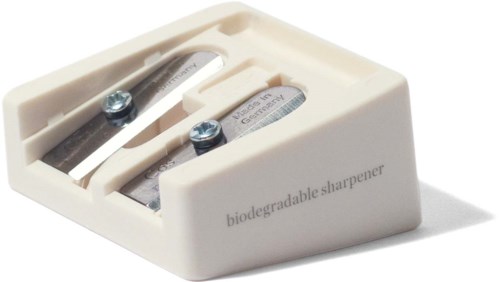Een witte plastic slijper met twee metalen messen en schroeven, gemarkeerd als biologisch afbreekbaar.