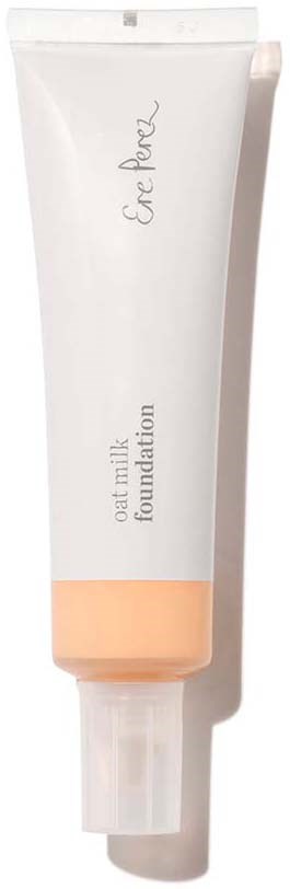 Een witte tube met een perzikkleurige band onderaan, gemerkt 'oat milk foundation' en een merknaam bovenaan.