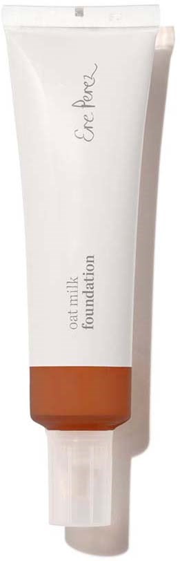 En vit tub märkt 'Oat Milk Foundation' med ett brunt band nära botten. Den har ett vitt lock.