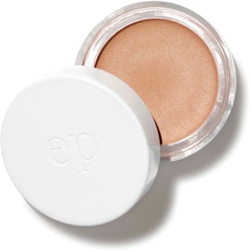 En liten rund behållare med beige makeup och ett vitt lock med bokstäverna "ep" på.