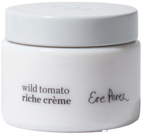 Een witte pot met zwarte tekst en handtekening, gelabeld "wild tomato riche crème" en "Ere Perez."