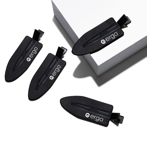 Vier schwarze USB-Sticks mit 'ergo' sind nahe einer weißen Box platziert, einer auf einer erhöhten Oberfläche.