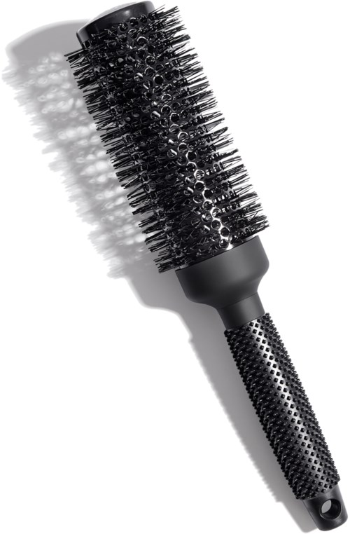 Eine schwarze runde Haarbürste mit strukturiertem Griff und Borsten, wirft Schatten auf eine weiße Oberfläche.