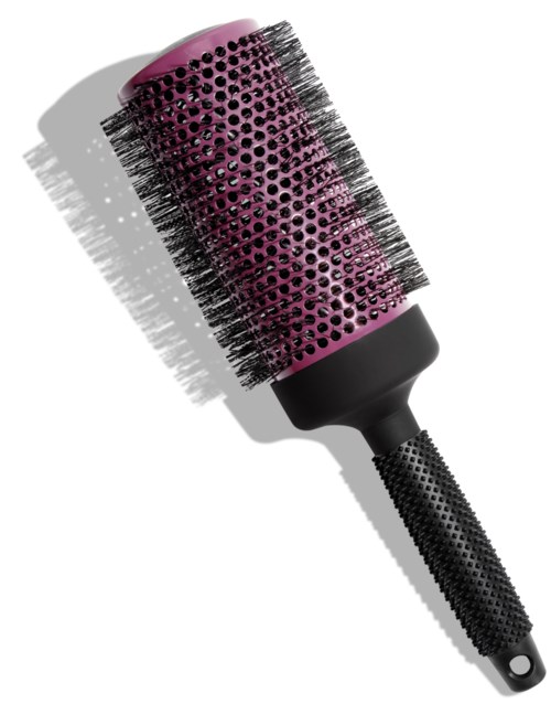 Eine rosa runde Haarbürste mit schwarzen Borsten und Griff, wirft einen Schatten auf eine weiße Oberfläche.
