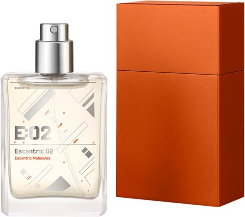 Ein Parfümflasche mit silberner Sprühkappe und weißem Etikett, neben einem orangefarbenen Karton.
