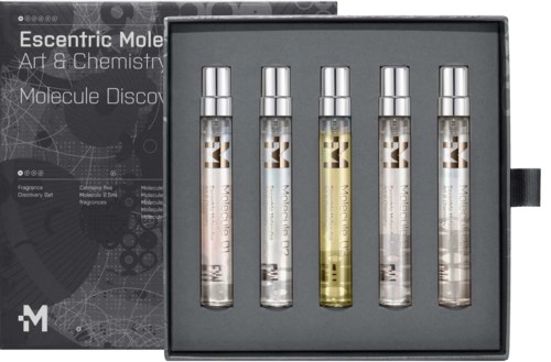 A set of five small bottles labeled with molecular terms inside a box. The box and bottles are related to art and chemistry.