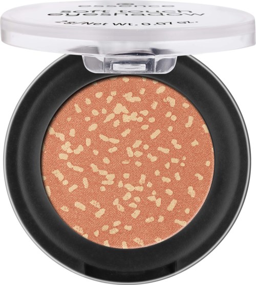 A makeup compact with a peach-colored blush that has small, yellowish speckles.