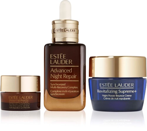 Three Estée Lauder skincare products with gold caps, including a night repair serum, a cream in blue jar, and a small eye cream.