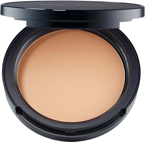 Open compact powder case showing beige pressed powder inside. Circular black container with a clear lid.