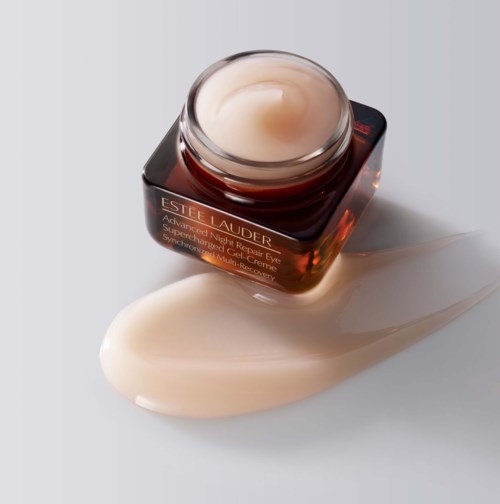 Een potje Estée Lauder oogcrème met wat creme die op een witte ondergrond is gemorst.