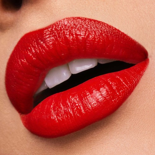 Close-up van lippen met felrode lipstick, licht geopend, toont witte tanden.