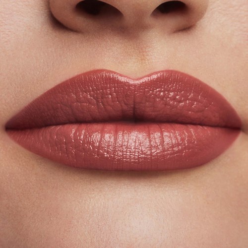 Nahaufnahme von Lippen mit glänzender, rosa Lippenstift und glatter Haut um den Mund.