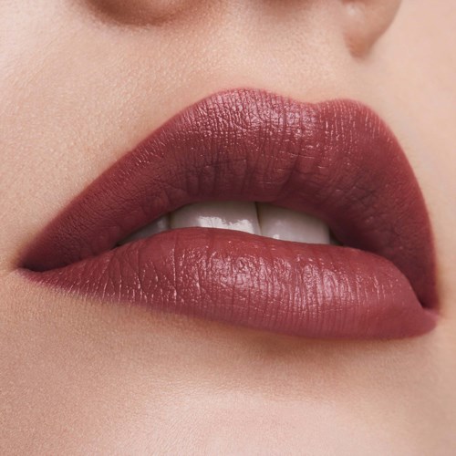 Nahaufnahme von den Lippen einer Person mit dunklem Lippenstift, leicht geöffnet, die Zähne zeigend.