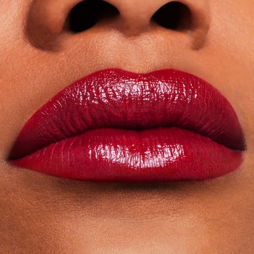 Close-up van lippen met glanzende rode lipstick, en deel van de neus zichtbaar.