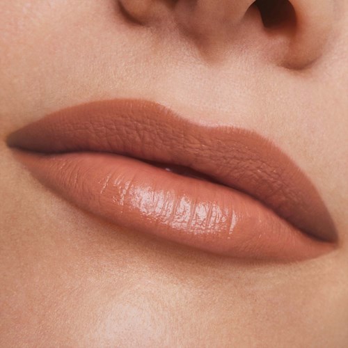 Nahaufnahme der Lippen mit natürlichem, nudefarbenem Lippenstift und glatter Haut.