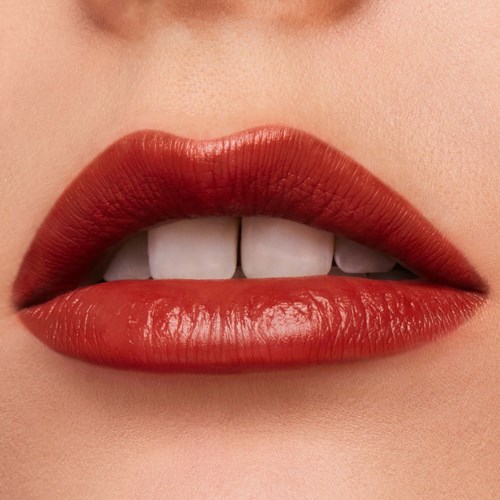 Nahaufnahme von Lippen mit rotem Lippenstift, leicht geöffnet, zeigt weiße Zähne.