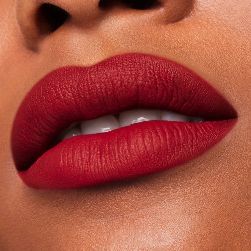 Close-up van lippen met felrode lipstick, licht geopend met tanden zichtbaar.