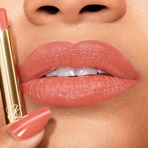 Close-up van lippen die roze lipgloss krijgen, deel van een gezicht met een neus erboven.