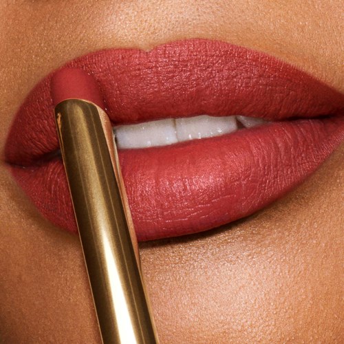 Close-up van lippen met rode lipstick die lipstick aanbrengt.