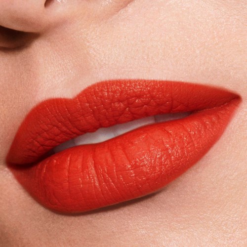 Close-up van lippen met rode lipstick, licht open en witte tanden zichtbaar.