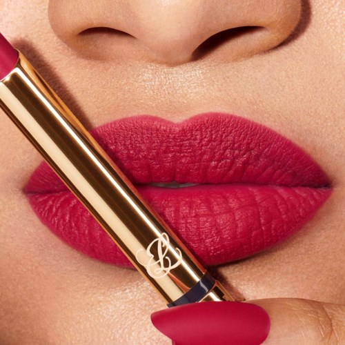 Close-up of red lips holding a gold-colored lipstick, with part of the face and nose visible.