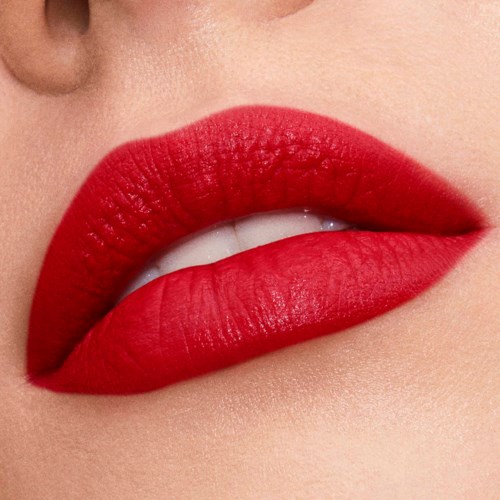 Close-up of lips painted bright red, slightly parted showing teeth.