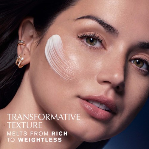 Close-up van het gezicht van een vrouw met een gladde huid en een witte penseelstreek op haar wang, promotie voor make-up of huidverzorging. Tekst over transformerende textuur.