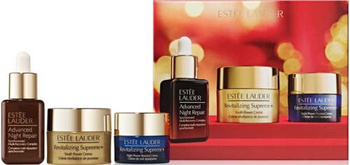 Display of various Estee Lauder skincare products with gold and blue packaging, arranged in front of a red and blurred background.
