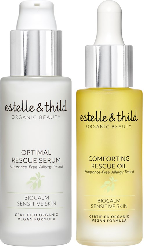 Twee flessen huidverzorgingsproducten, een witte en een gele, met zilveren doppen en labels. Ze zijn van Estelle & Thild.