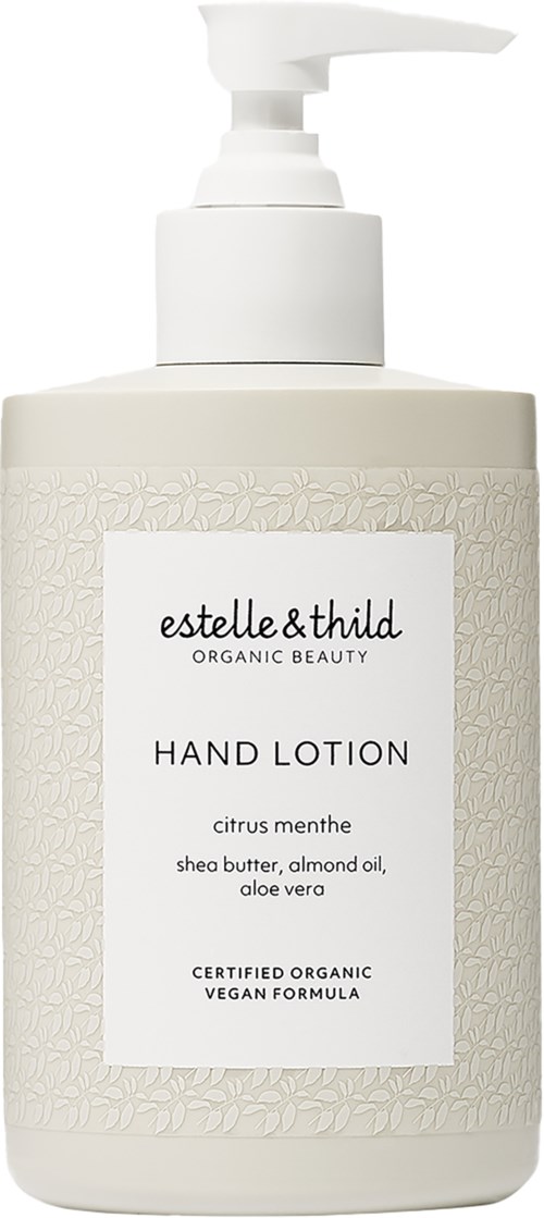 Een witte pompflacon handlotion met een getextureerd label, merknaam 'estelle&thild' en ingrediënten zoals sheaboter en aloe vera.