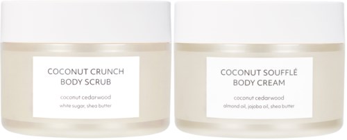 Twee potten met lichaamscrème en lichaamsscrub met kokosgeur, één gelabeld 'Coconut Crunch' en de andere 'Coconut Souffle'.