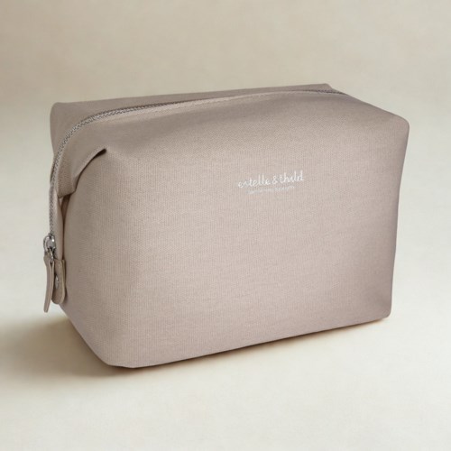 A beige fabric toiletry bag with a zipper and white text on the front.