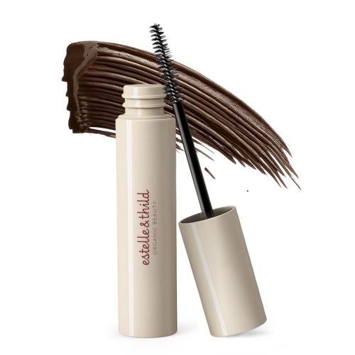 A white mascara tube with an open cap and wand, with brown mascara swiped behind it.