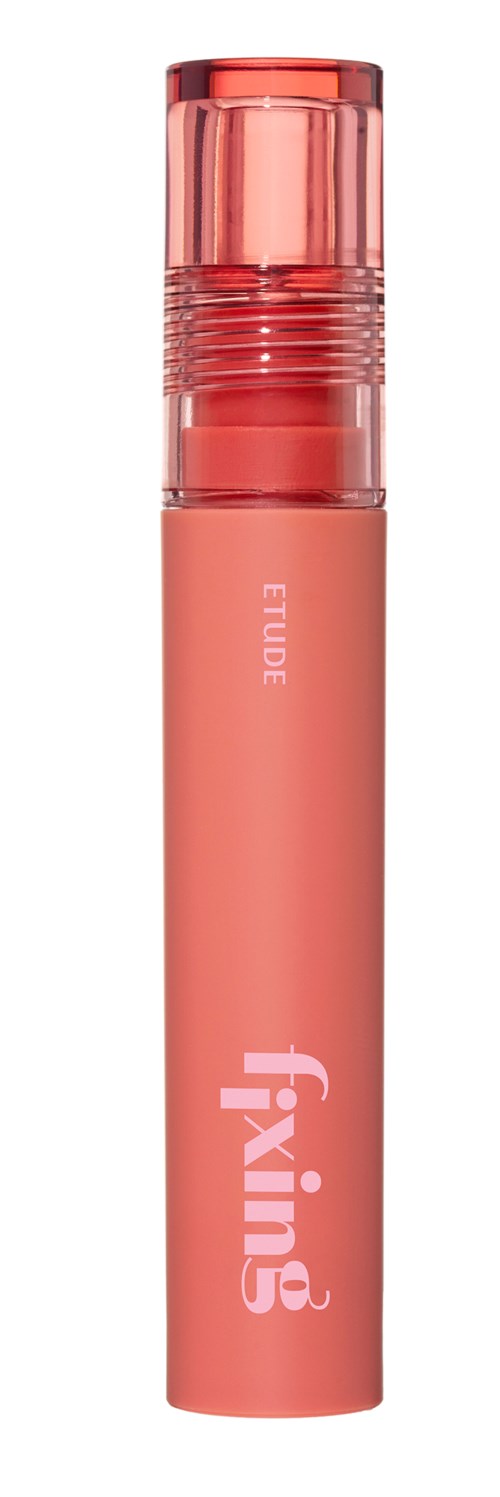 A pink cylindrical container with a clear cap, labeled Fixing, used for cosmetic or skincare purposes.