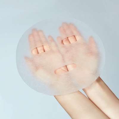 Een hand houdt een ronde, doorzichtige filter vast waardoor een andere hand met vier vingers en een ring zichtbaar is.