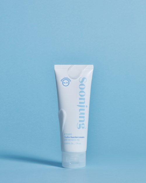 Een witte tube zonnebrandcrème staat tegen een lichtblauwe achtergrond.